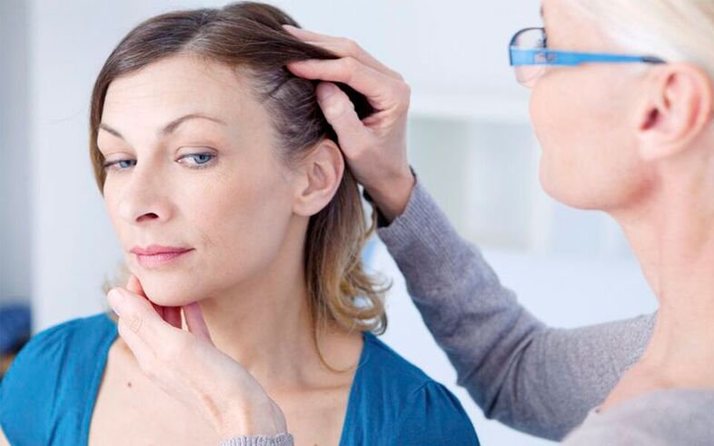 The doctor diagnoses psoriasis on the head