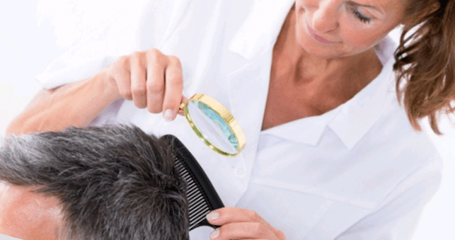 doctor checking psoriasis on head