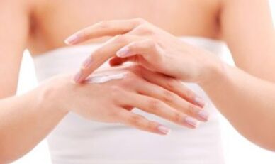 Girl applying ointment on her hands